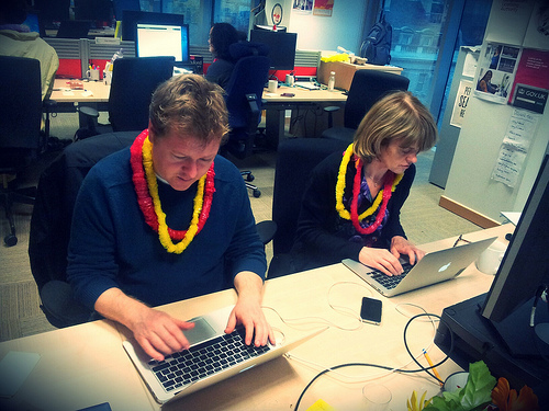 Photo of a man and woman working on laptops