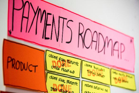 Pay team’s wall with sign saying “Payments roadmap”