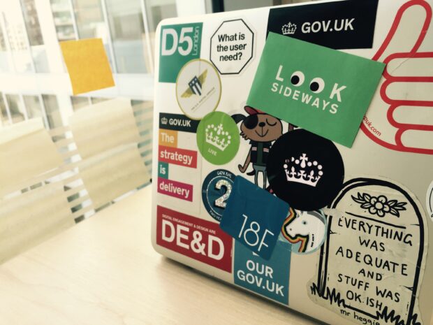 Photo of a laptop covered in GDS stickers - including a "Look Sideways" sticker