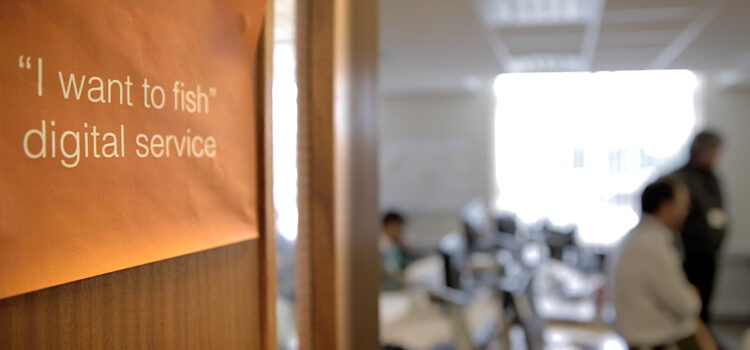 Poster on a door - "I want to fish: digital service" - blurred office scene in background