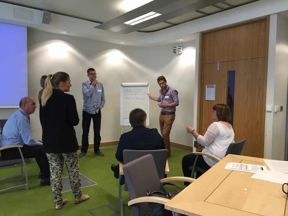 People standing and sitting around flipchart