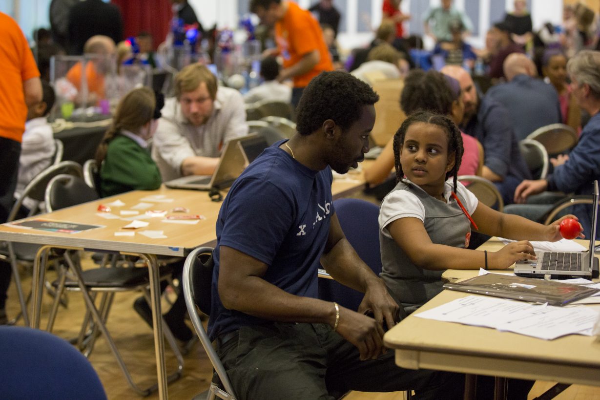 A child at Dragon Hall being coached by an adult man