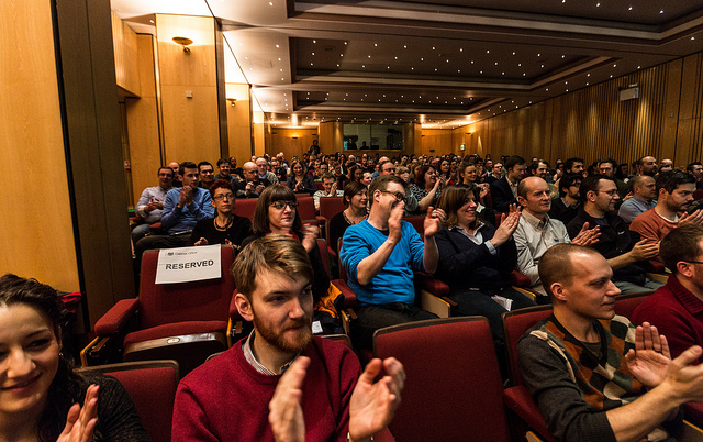 An auditorium filled with GDS staff applauding a speaker at the first GDS all-staff meeting.