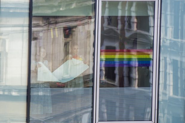 Photo showing GDS staff putting rainbox-coloured stripes in the windows at GDS