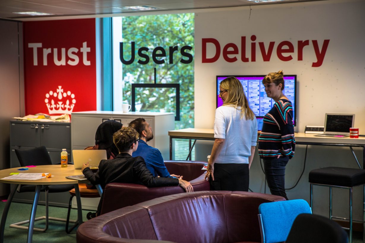 GDS staff in front of the Trust, users, delivery wall sign