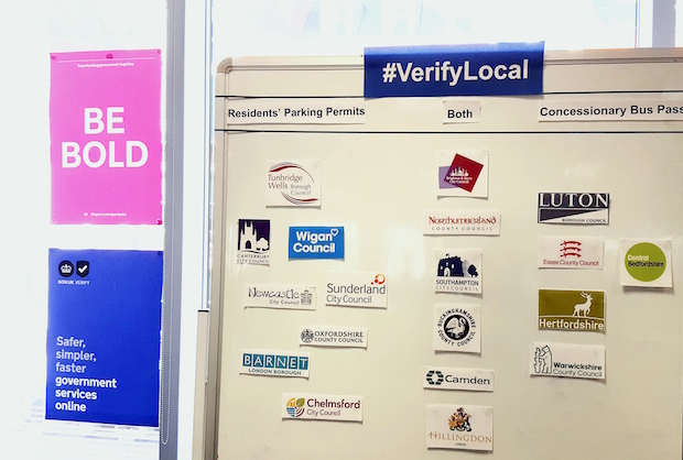 Wall showing a list of local authorities signed up for #VerifyLocal project, including Wigan Council, Chelmsford City Council, Camden Council, Warwickshire County Council, Sunderland City Council and others.