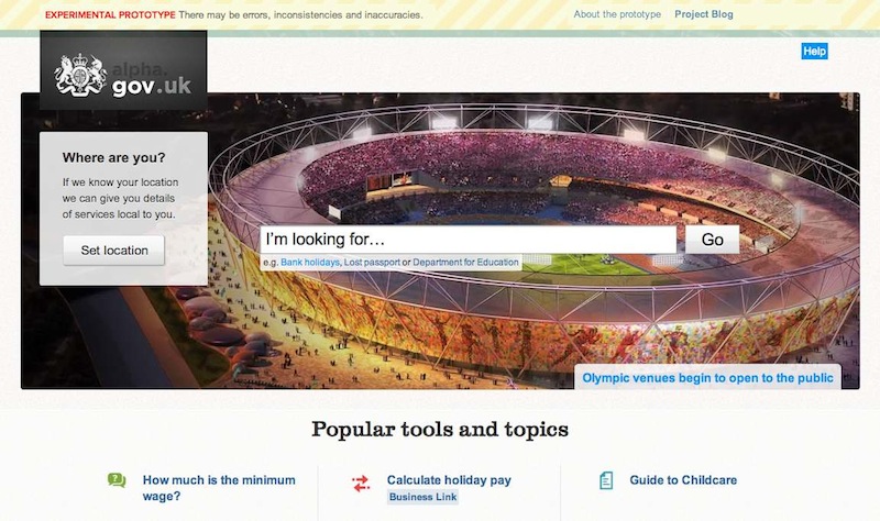 The GOV.UK alpha home page on launch day. There is a large header image of the Olympic stadium with the GOV.UK search bar over the top of it.