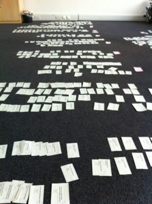 The floor in Hercules House covered in hundreds of user needs on white flash cards grouped in rows. 