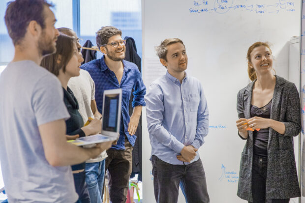 GOV.UK team members standing in front of a whiteboard