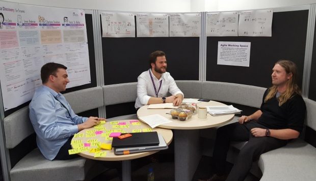 3 DfT discovery team members sitting around a table and talking