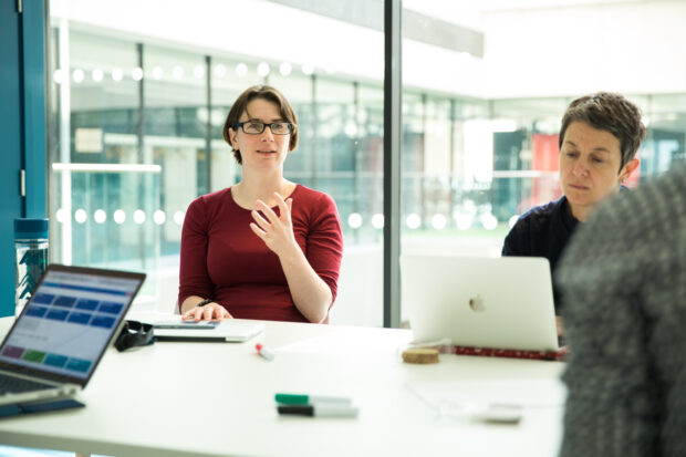 Anna Shipman and another member of GDS staff sitting at a desk, talking