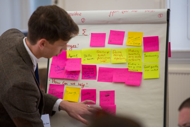 Discovery session at Blog Camp - facilitator in front of a board with post-its