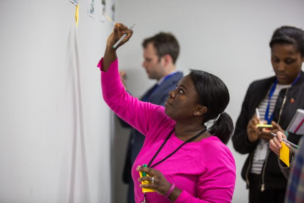 Workshop participants putting post-its on the wall