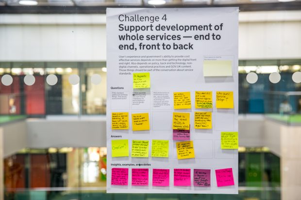 a poster from one of the workshop with post-it notes with ideas, the only legible piece of text on it is 'Challenge 4: Support development of whole services - end to end, front to back' 