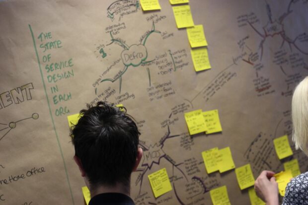 Head of Design Lou Down looking at service design charts for different government departments