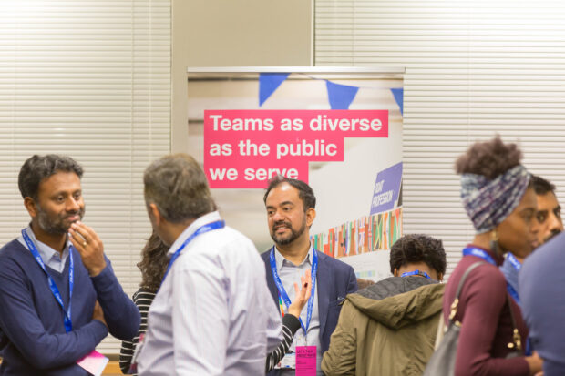 Eight people of different ethnicities talking at the event 