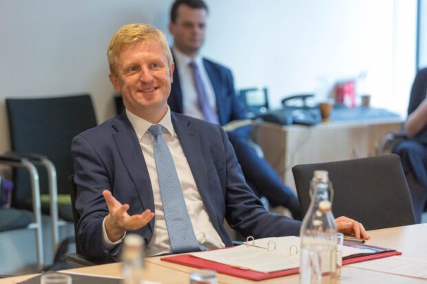 Oliver Dowden sitting at a table and talking