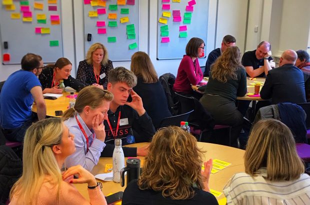 workshop participants sitting around 3 round tables