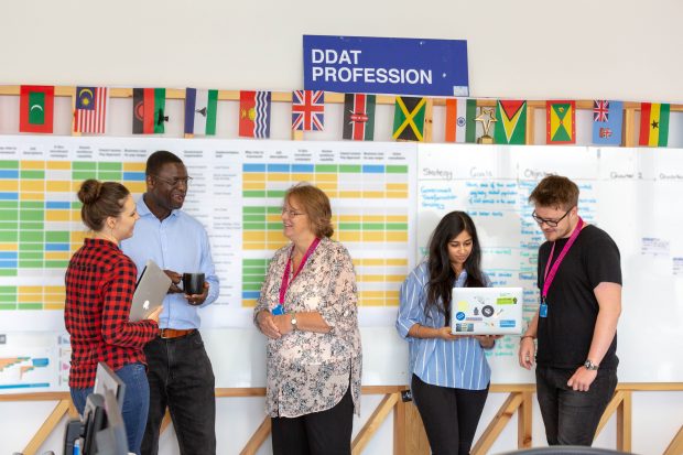 5 people standing in front of a board with a roadmap on it and a sign saying 'DDaT Profession'