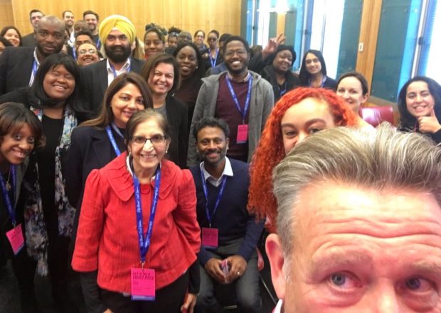 Kevin Cunnington taking a selfie at Lets Talk About Race event, with a large group of people standing behind him facing the camera