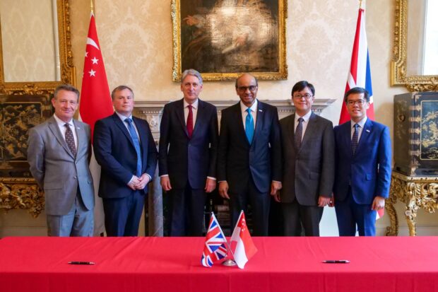 Kevin Cunnington at the signing of a memorandum of understanding between the UK and Singapore governments. 6 people, including Kevin, standing in a row and facing the camera