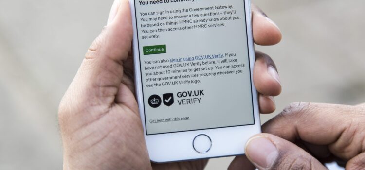 mobile phone screen displaying Verify page, the user's hands holding the phone are also visible
