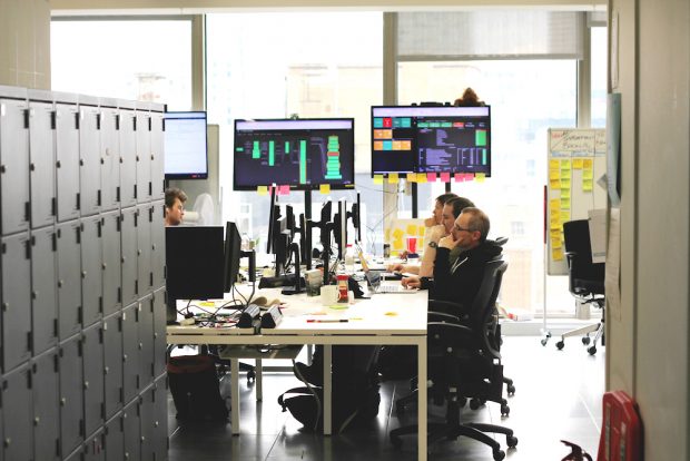 Members of the GOV.UK Verify team at work, sitting at desks and looking at their computer screens