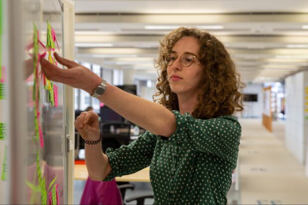 Anna putting post-it notes on a whiteboard