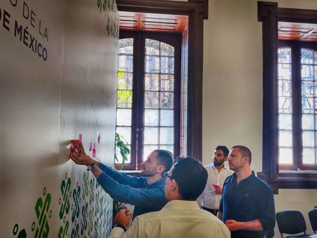 People are putting post-it notes on a wall