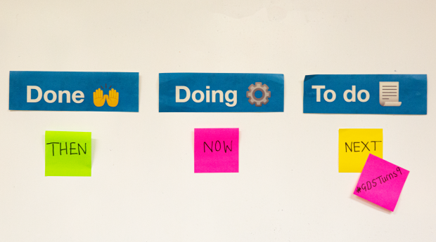 Under the column heading "Done" is a sticky note that reads "Then". Under the column heading "Doing" is a sticky note that reads "Now". Under the column heading "To do" is a sticky note that reads "Next". Another sticky note is attached to it, which reads "#GDSTurns9".