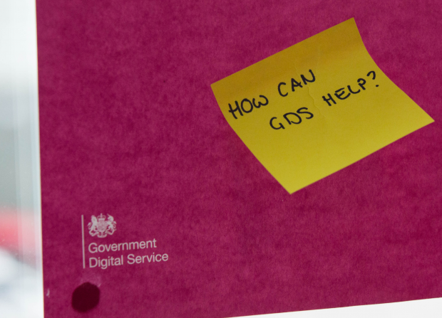 A sticky note reading "How can GDS help?" stuck on a poster with the Government Digital Service (GDS) logo.