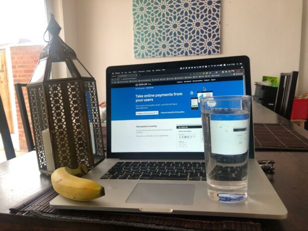 A banana and glass of water rest on a laptop.