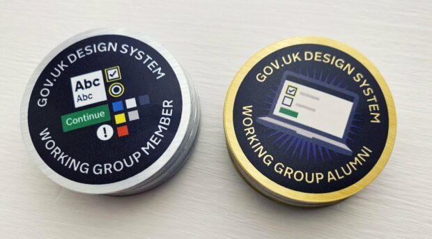 Two stickers made for the GOV.UK Design System Working Group. One shows design elements of a service: text, button, radio and checkmark, with text saying Working Group member. The other shows a laptop with a completed service, saying Working Group Alumni.