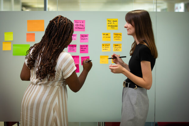 Two women working at a group of post-its
